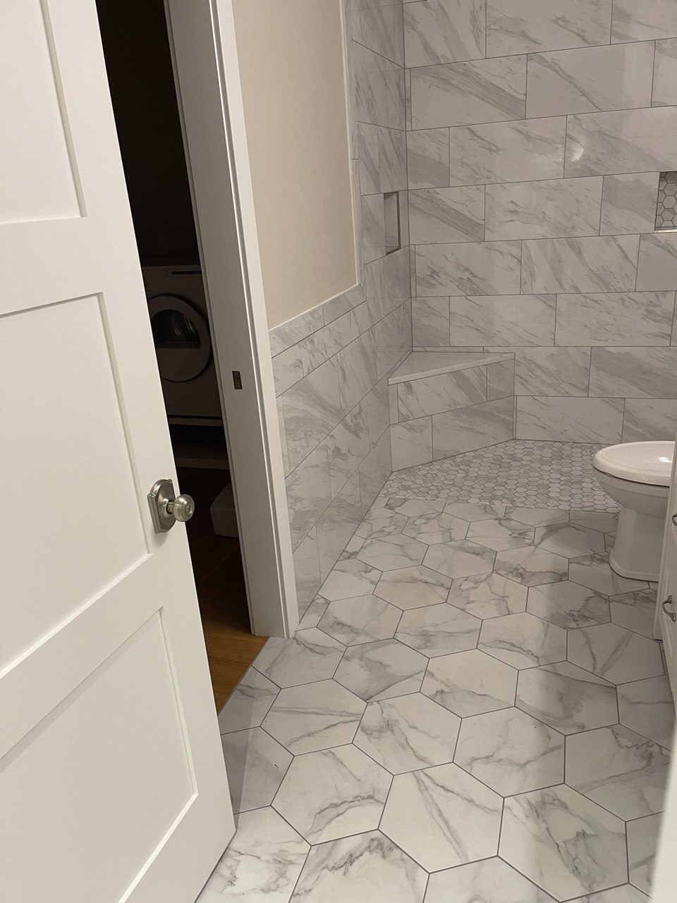 Marble-look tiled bathroom seen from the doorway